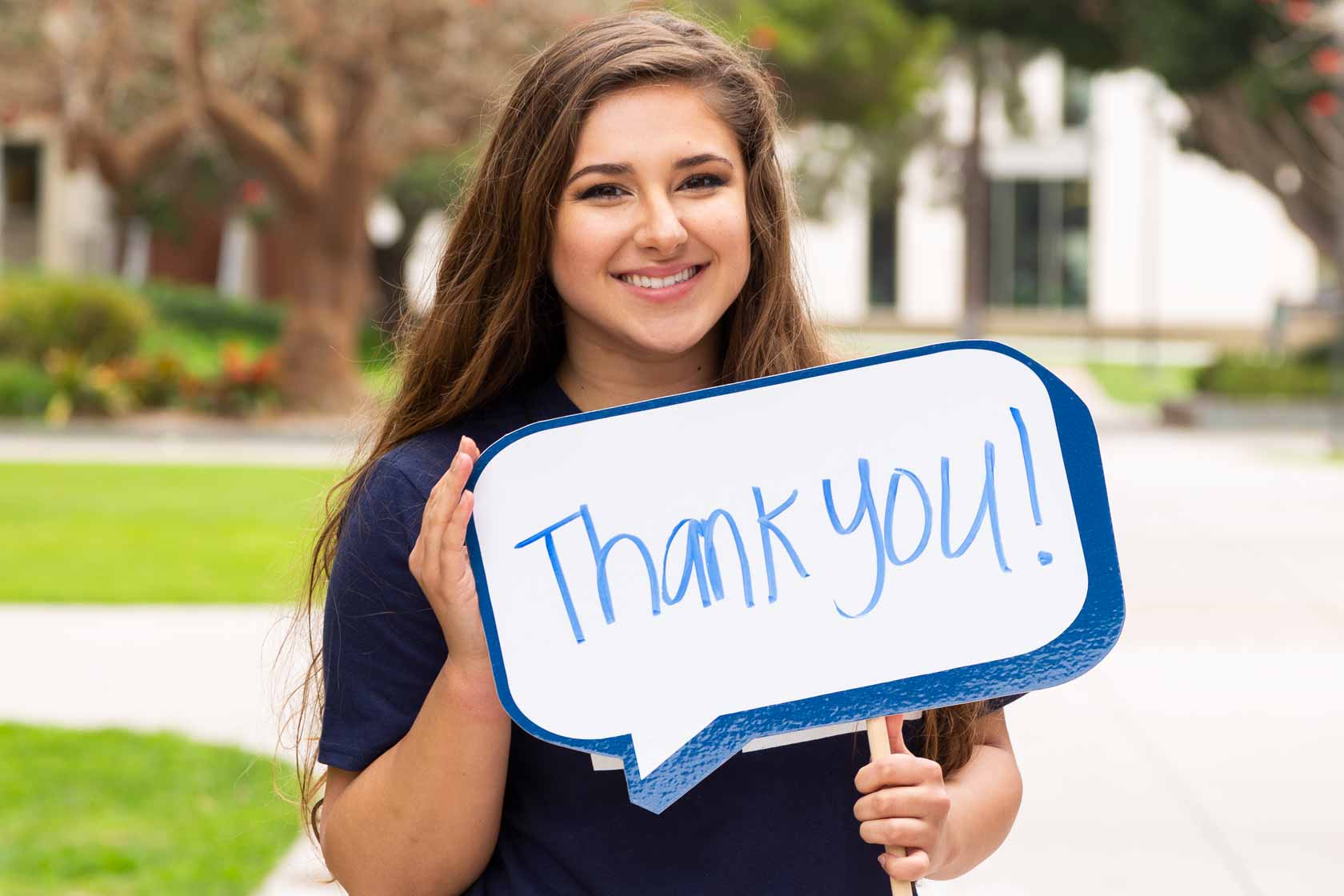 Student with thank you sign